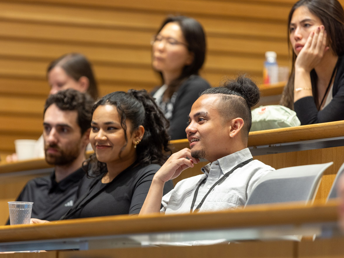 Several audience members watching a talk