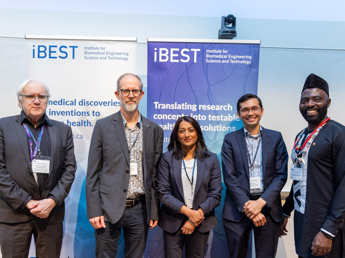 Dr. John Marshall , Dr. Simon Graham, Dr. Natasha Rajah, Dr. Venkat Bhat and Dr. Jude Kong stand in front of iBEST banners. 