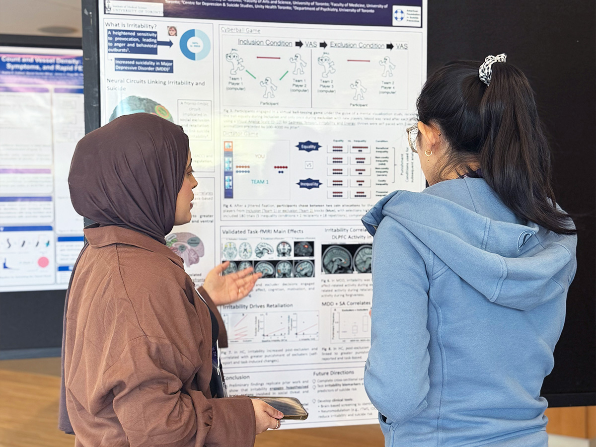 A student explains their research project as part of the 2025 iBEST Symposium student poster competition