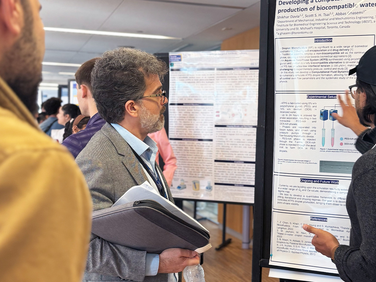 TMU professor and iBEST co-director Michael Kolios reviews a 2025 iBEST Symposium Student Poster Competition entrant’s project